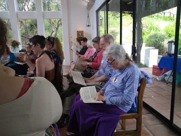 A group of singers sings from the Sacred Harp.