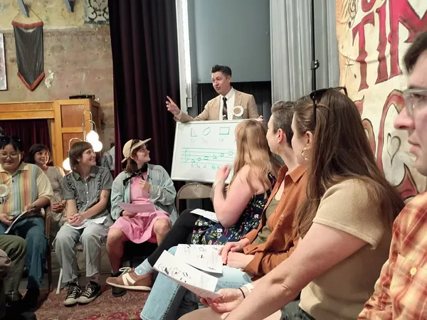 A shape-note singing school with a class learning how to read shape notes.