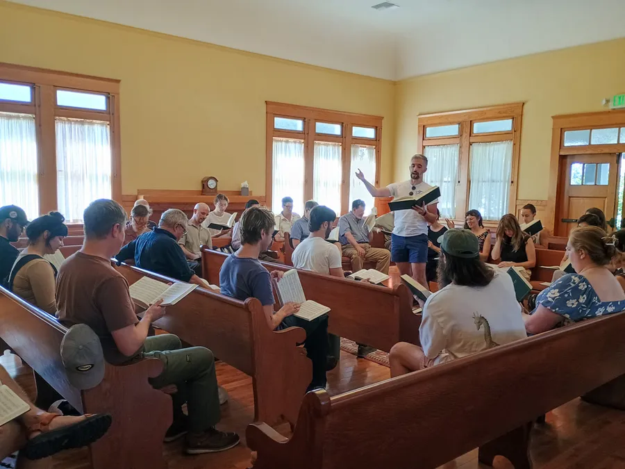 A singer leads a large class from the hollow square at the Orange Grove Friends Meetinghouse in Pasadena.